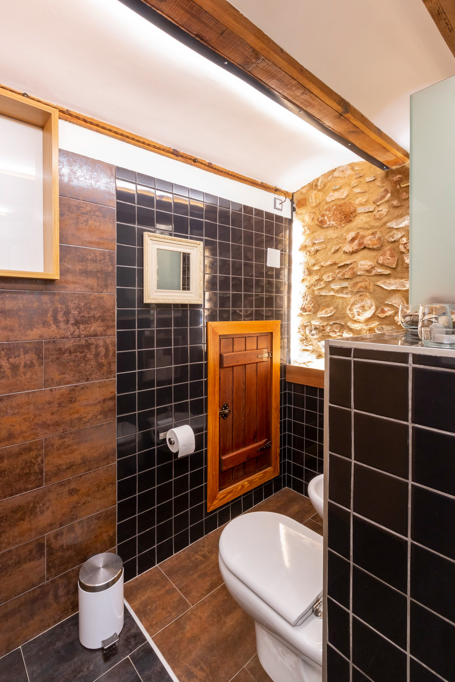 Baño superior con refuerzo de iluminación led indirecta en pared piedra y techos