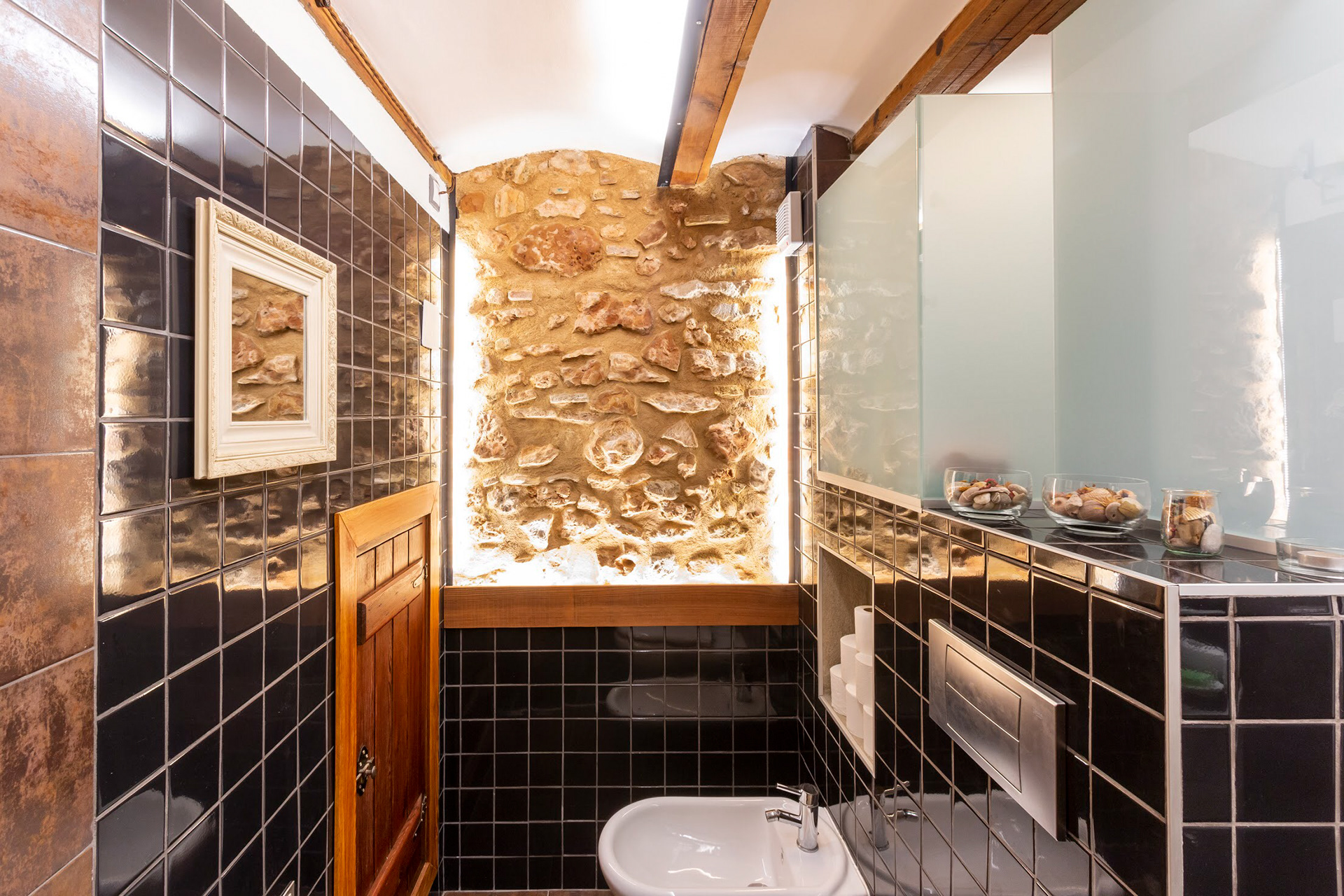 Baño superior con refuerzo de iluminación led indirecta en pared piedra y techos