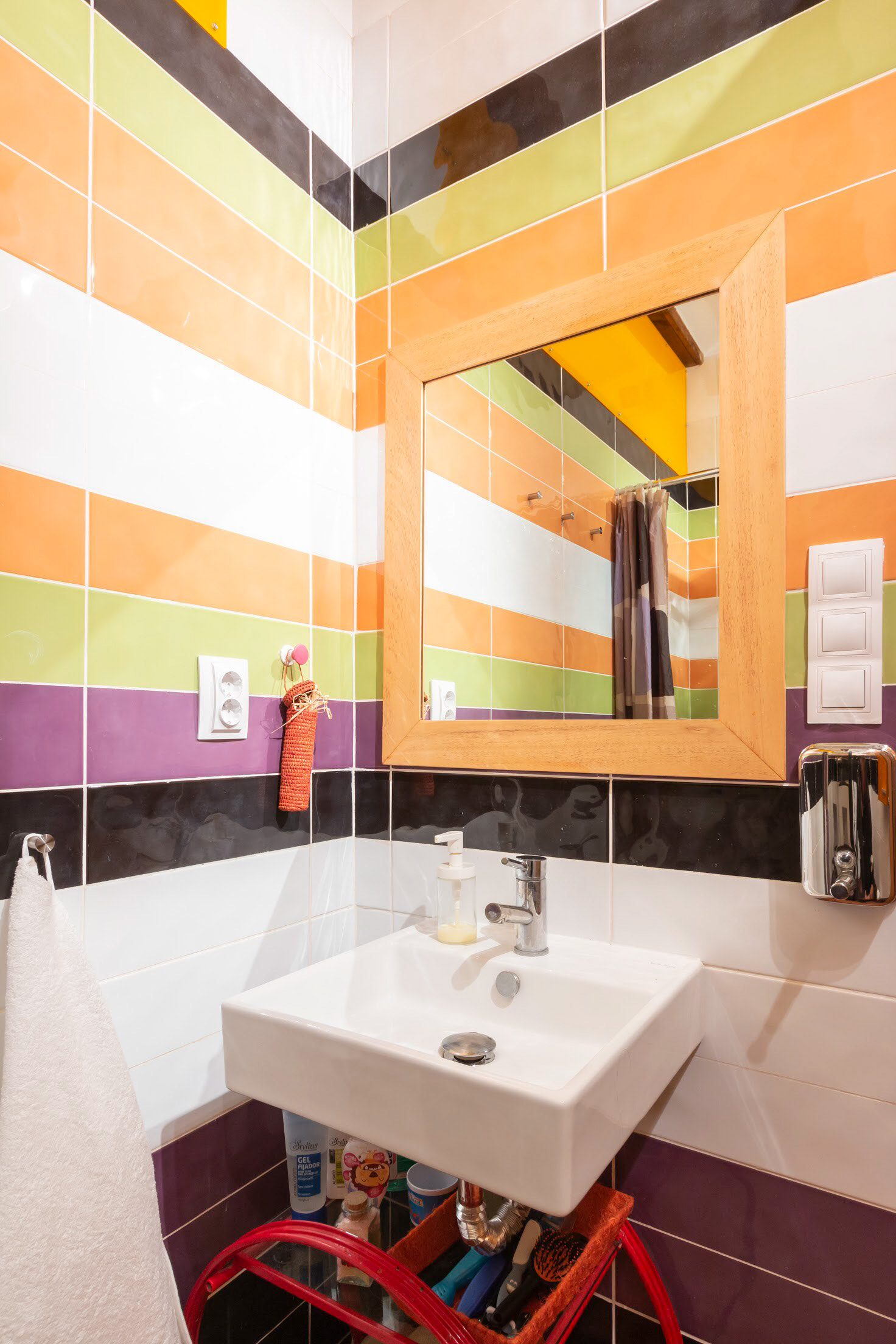 Baño inferior con techos altos y reforzado con ventanales superiores a escalera y comedor