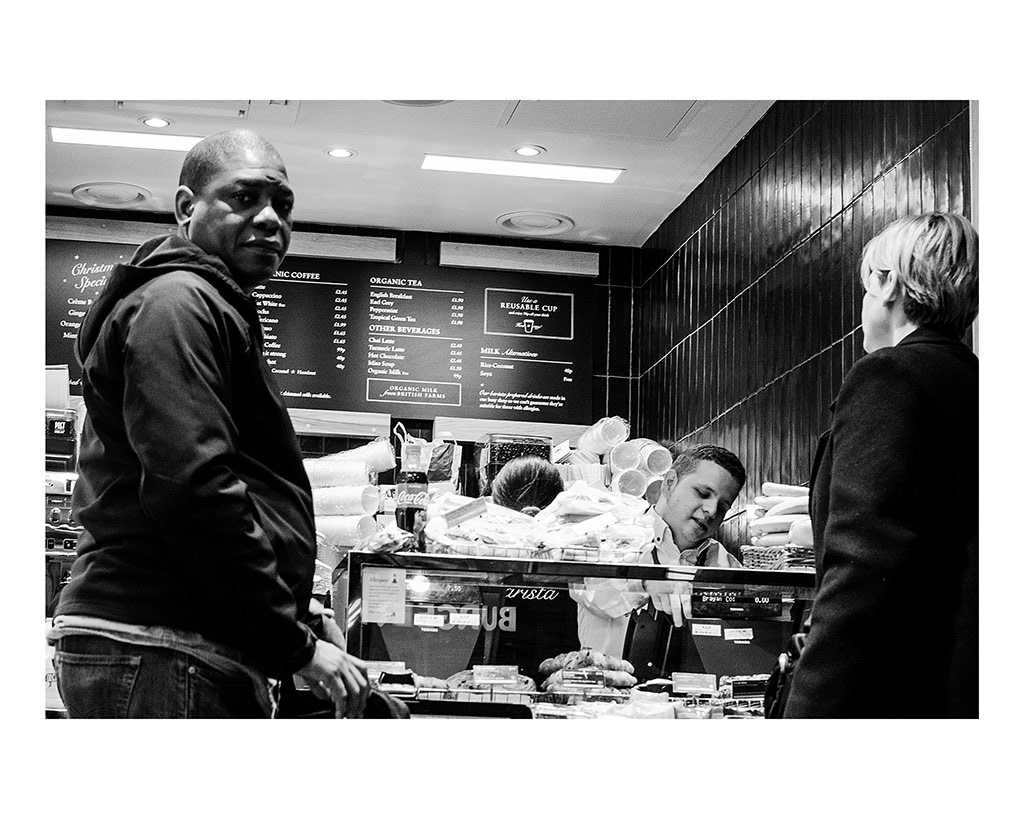 Isolation in London Transport; The City That Never Speaks. 3/5 Two customers stand awkwardly next to each other in a café as they wait to be served in London Victoria Station, England, November 26, 2018.