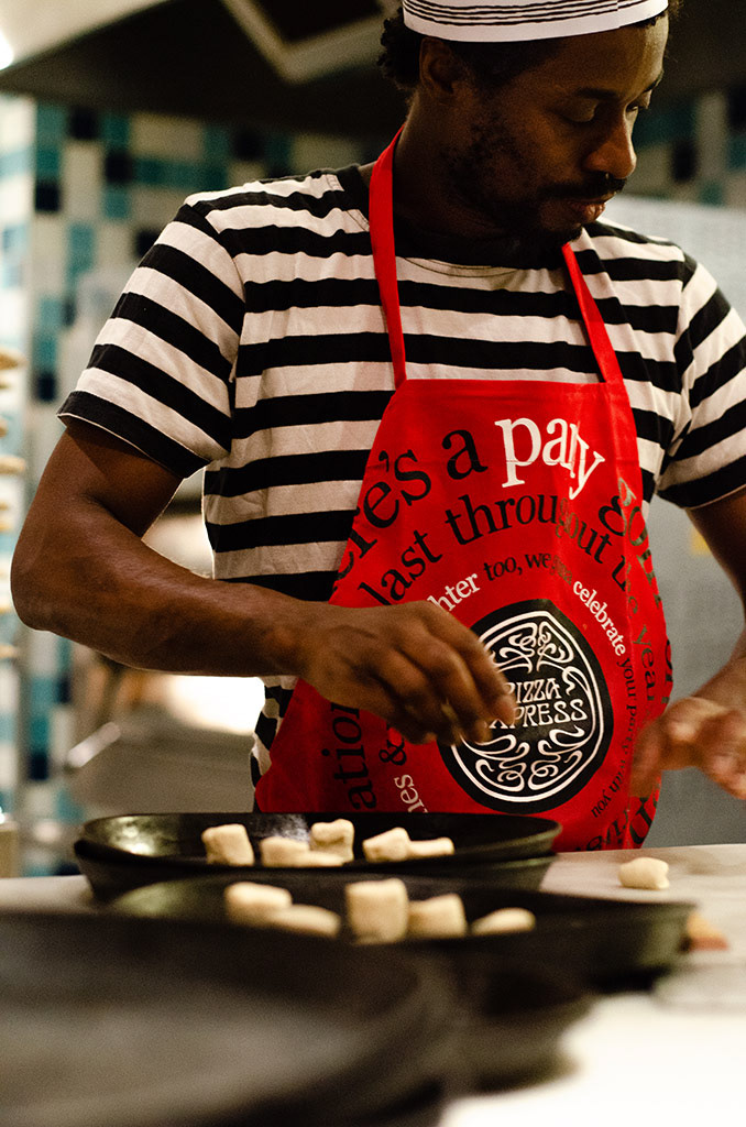 Peter, a chef at Pizza Express, prepares doughballs, one of their most popular dishes, for a few minutes in the oven, in Falmouth, England, December 1, 2018. 