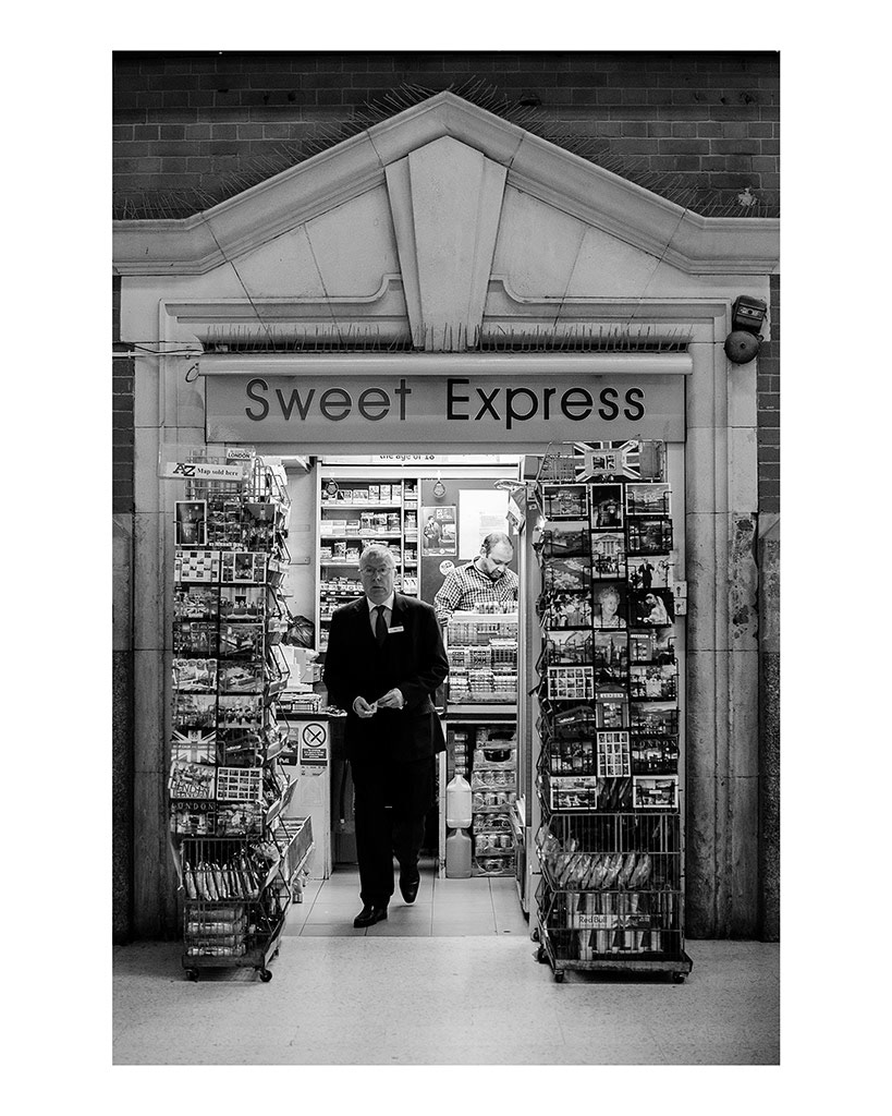 Isolation in London Transport; The City That Never Speaks. 4/5 A man walks out of a small shop after purchasing something from the shop owner in London Victoria Station, England, November 26, 2018. 