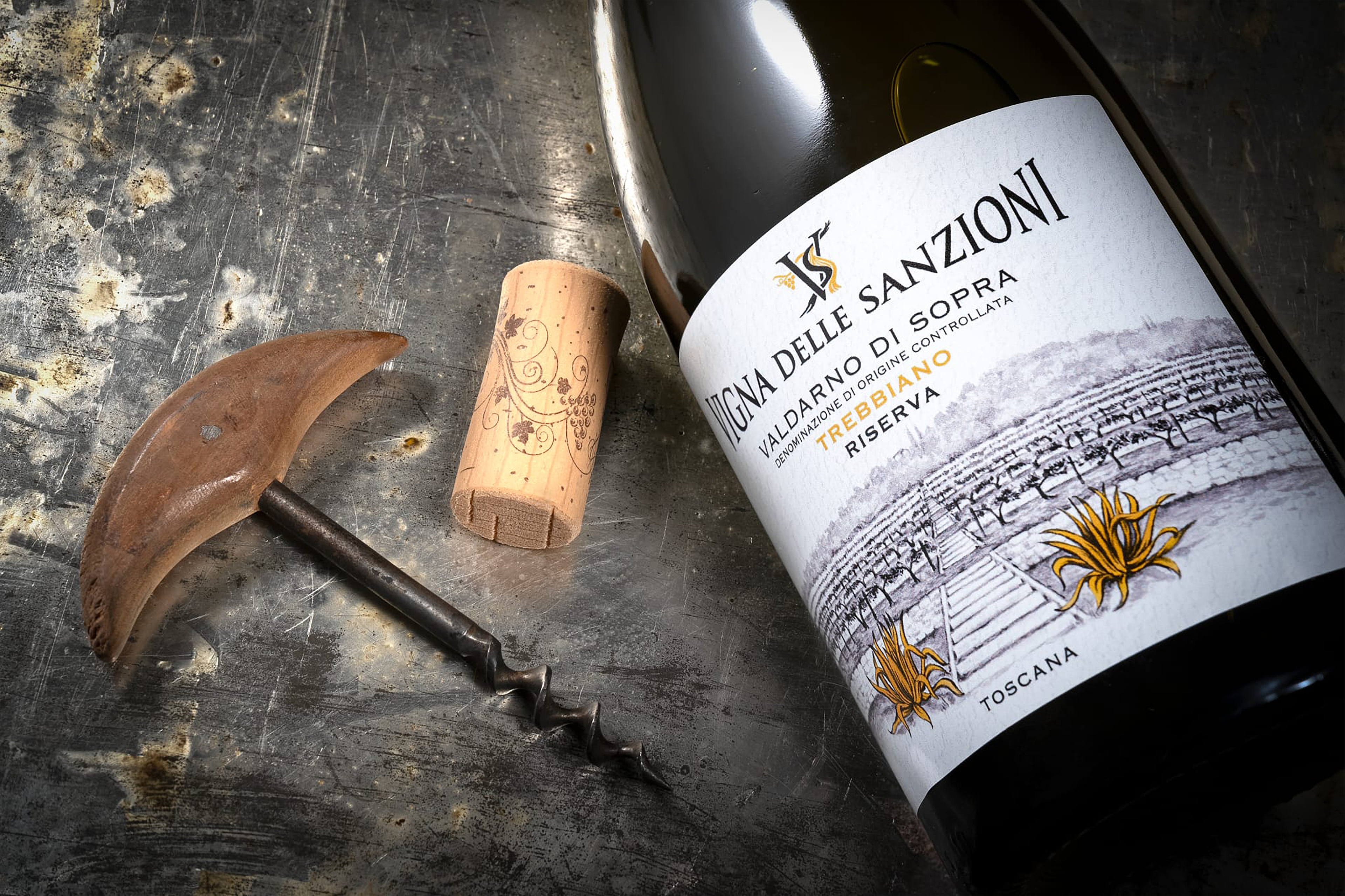 Particolare della bottiglia di Vigna delle Sanzioni Valdarno di Sopra DOC Trebbiano Riserva adagiata con accanto il tappo di sughero e il cavatappi