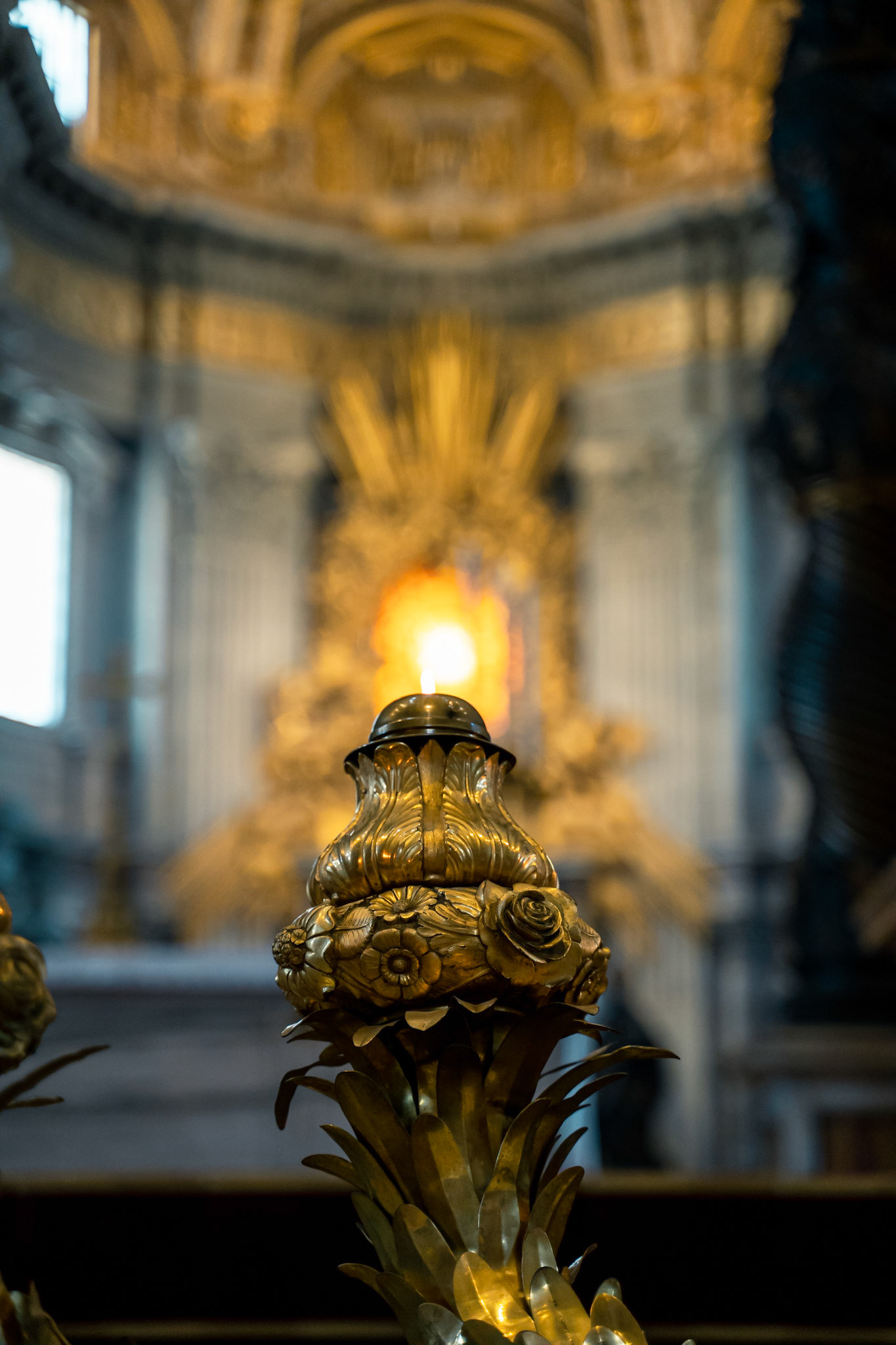 A candle in front of the Cathedra Petri and Gloria inside St. Peter's Basilica