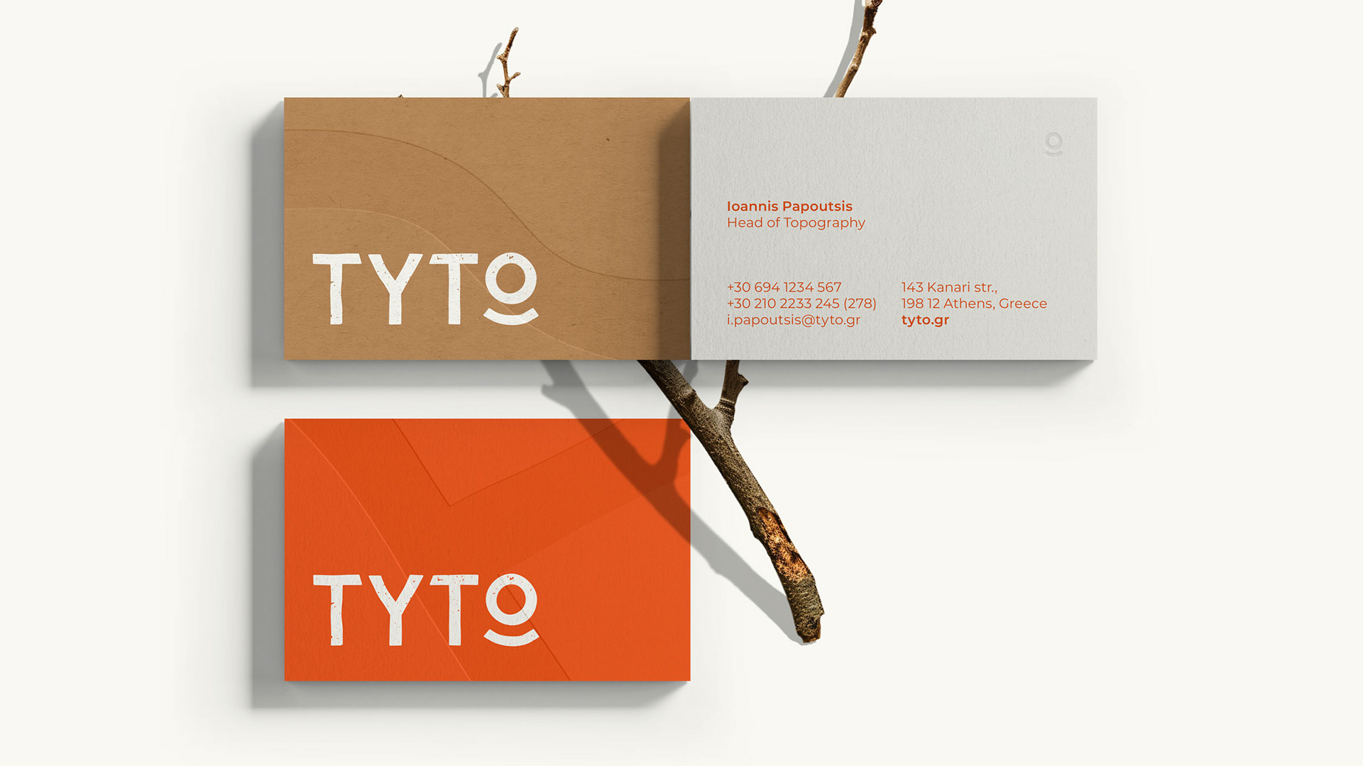 TYTO hiking business cards designed according to the brand. The image shows both sides of the card and two different back sides are shown. The backsides feature different lines that act as a supportive graphic to the brand embossed on them and the TYTO logotype in white print. Each back side is of a different paper, the first is in brown ecological paper and the second an orange paper. The front side is in a warm white paper. It features all information in the orange brand color and on the upper right corner the TYTO symbol is embossed.