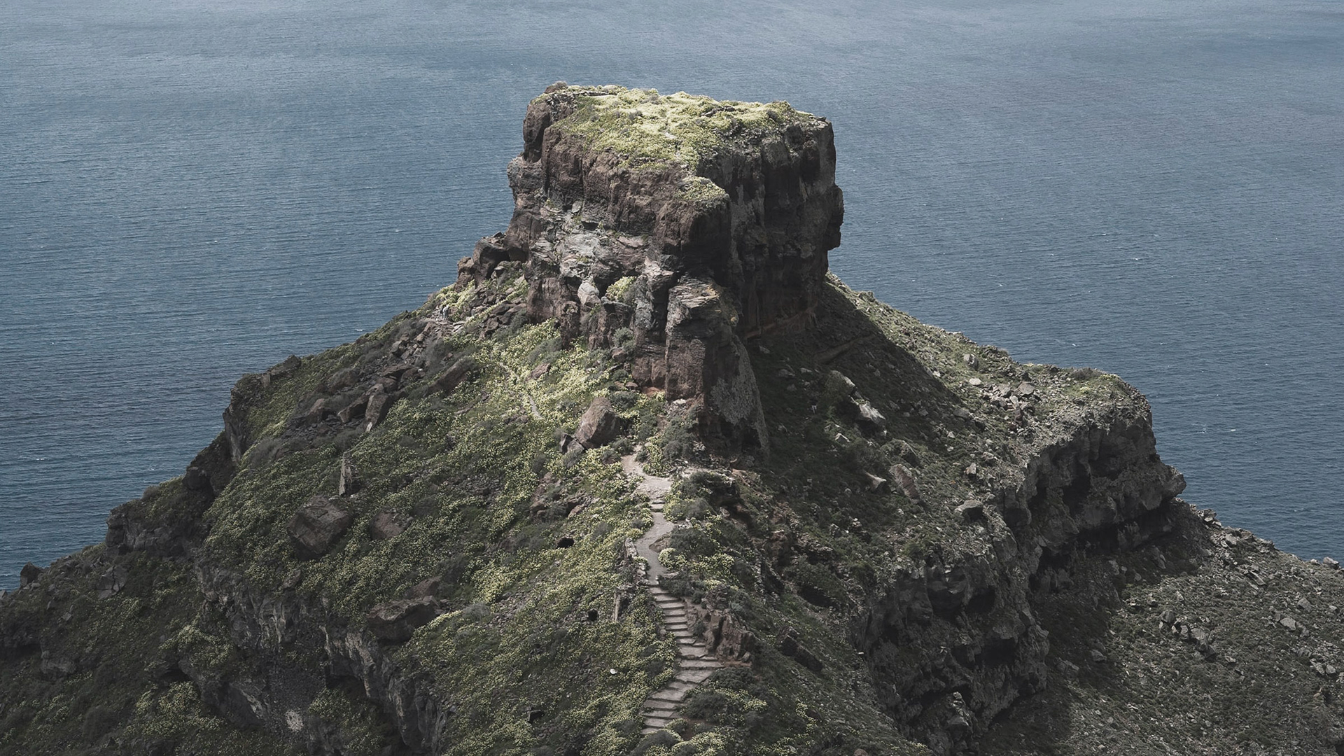 A rock in Santorini overlooking the sea.