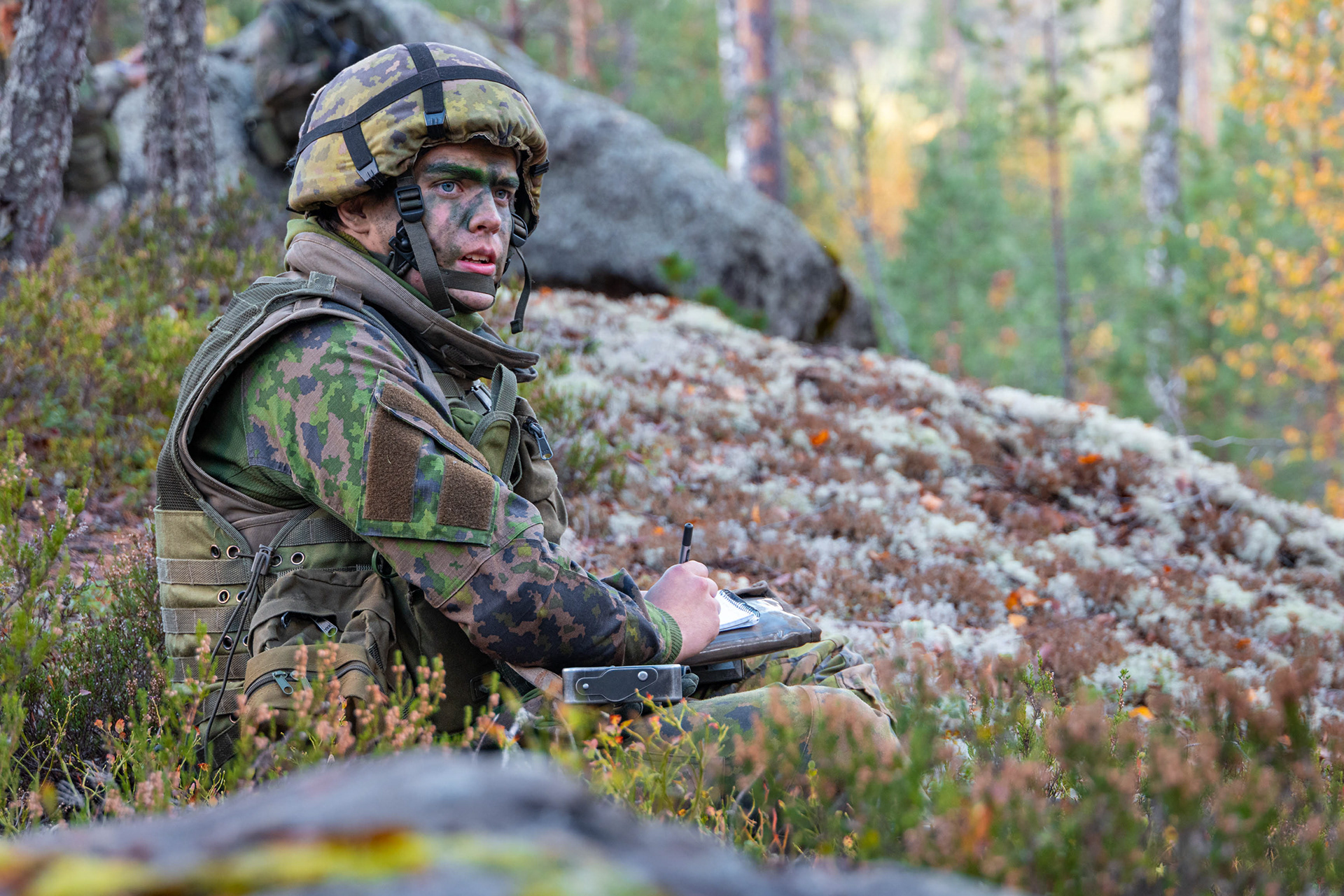 Aliupseerioppilas piirtämässä ryhmälleen karttaa ympäröivästä alueesta.