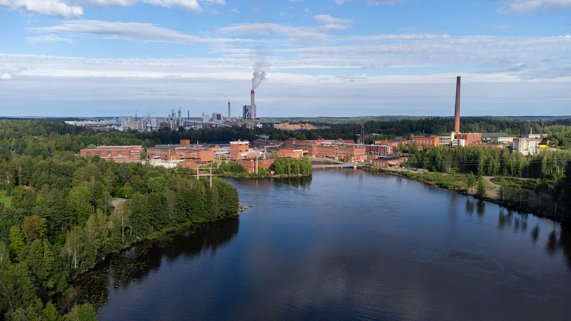 Kymin vanha tehdasalue ja Kymijoki. Taustalla nykyinen UPM Kymin paperitehdas. (8.2023)