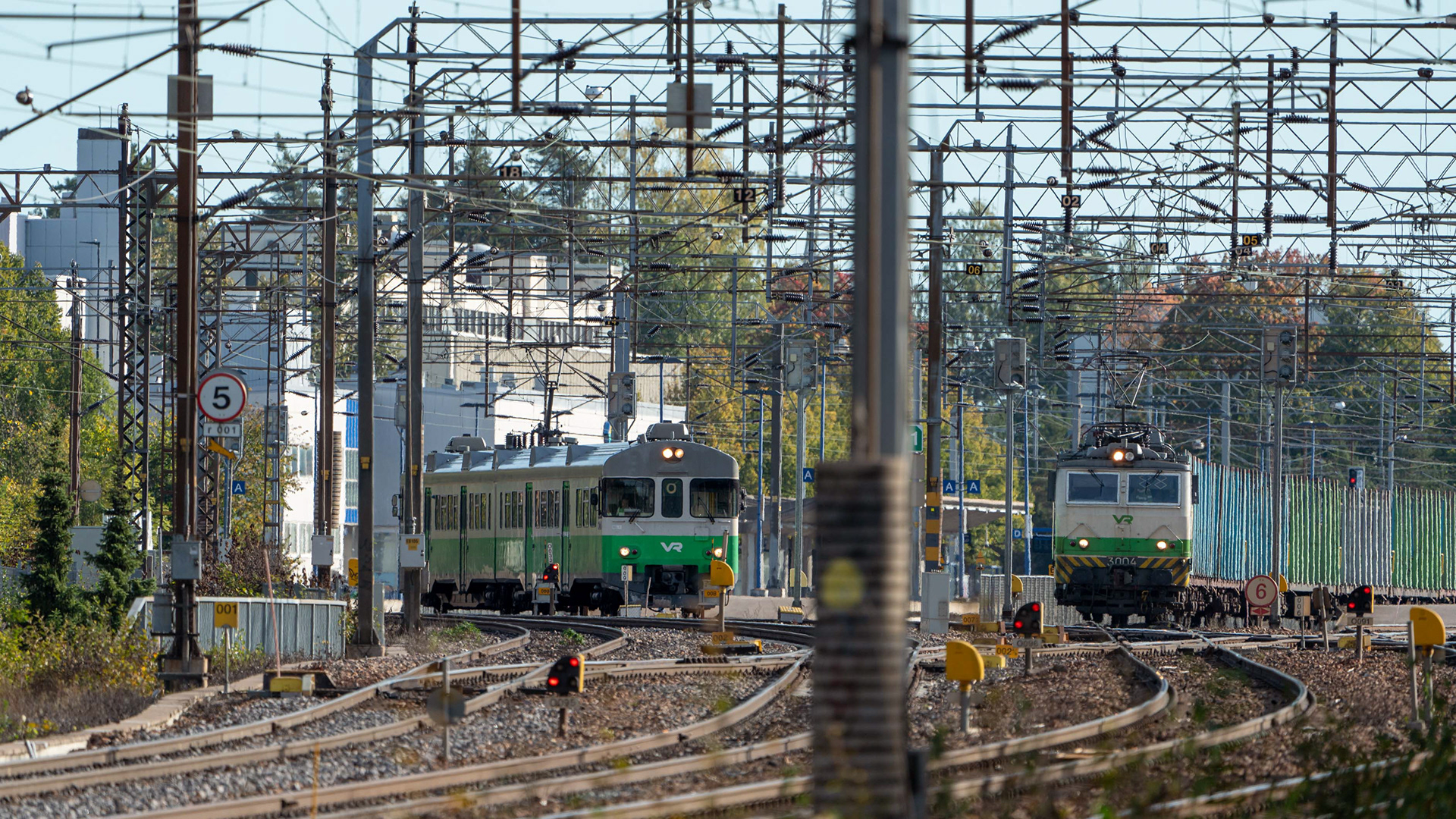 Kouvolan rautatieasema, jossa Sm2-lähijuna lähdössä Lahteen päin ja Sr1 raakapuuvaunuineen odottamassa lähtöä. (22.9.2024)