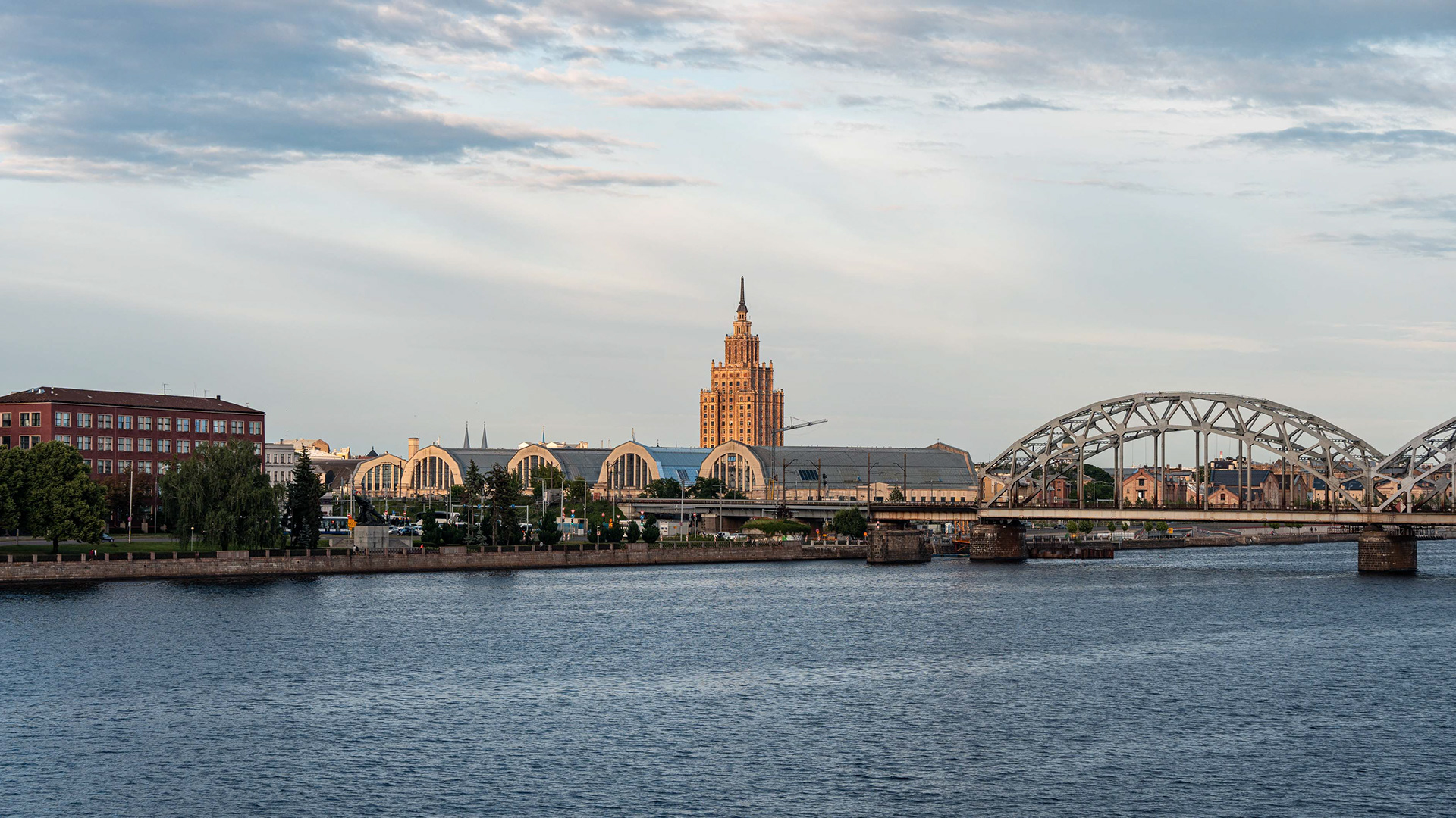Etualalla Väinä-joki, keskellä Riikan kauppahallirakennukset ja taustalla kohoaa Latvian tiedeakatemian tornimainen rakennus.