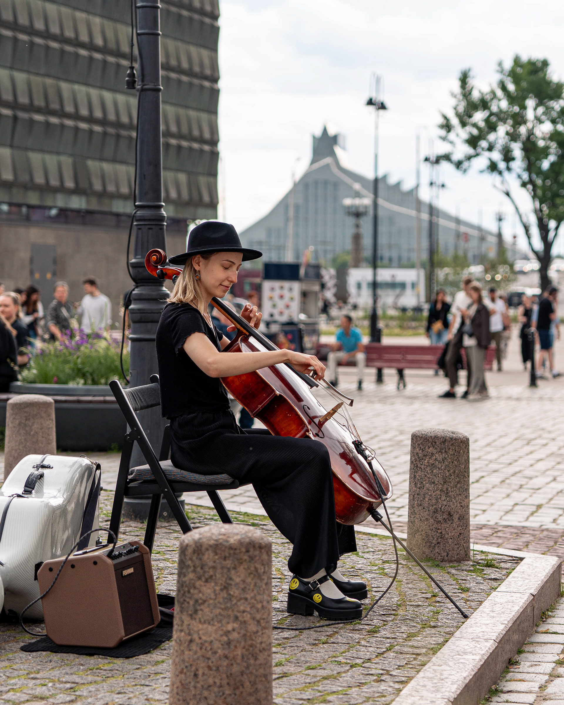 Sellonsoittaja viihdytti turisteja Mustapäiden talon aukiolla
