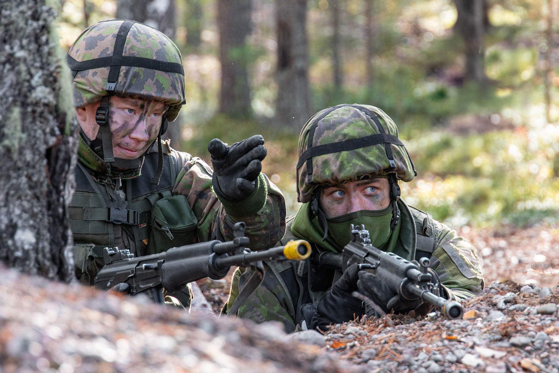Ryhmänjohtaja antamassa ohjeita puolustusasemissa olevalle ryhmän jäsenelle.