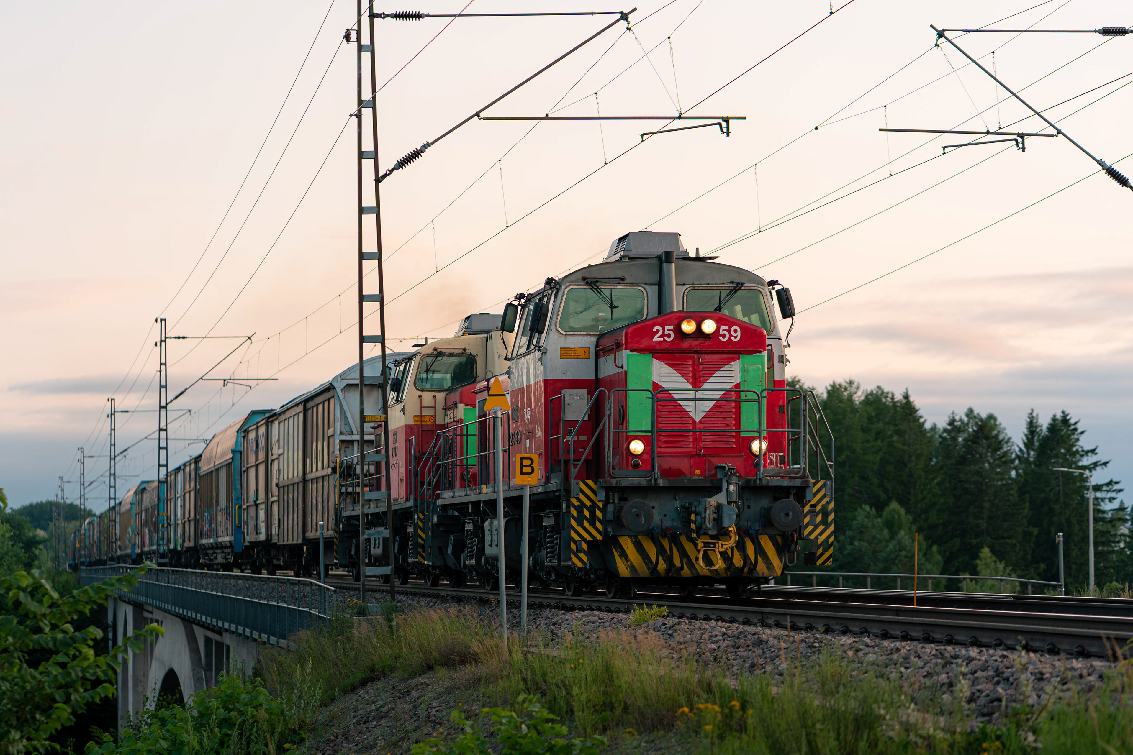 Kahden Dv12 dieselveturin vetämä tavarajuna kuljettamassa flutingia Stora Enson Heinolan tehtaalta kohti Kotkan satamaa. Kuva Korian sillan kohdalta. (13.7.2026)