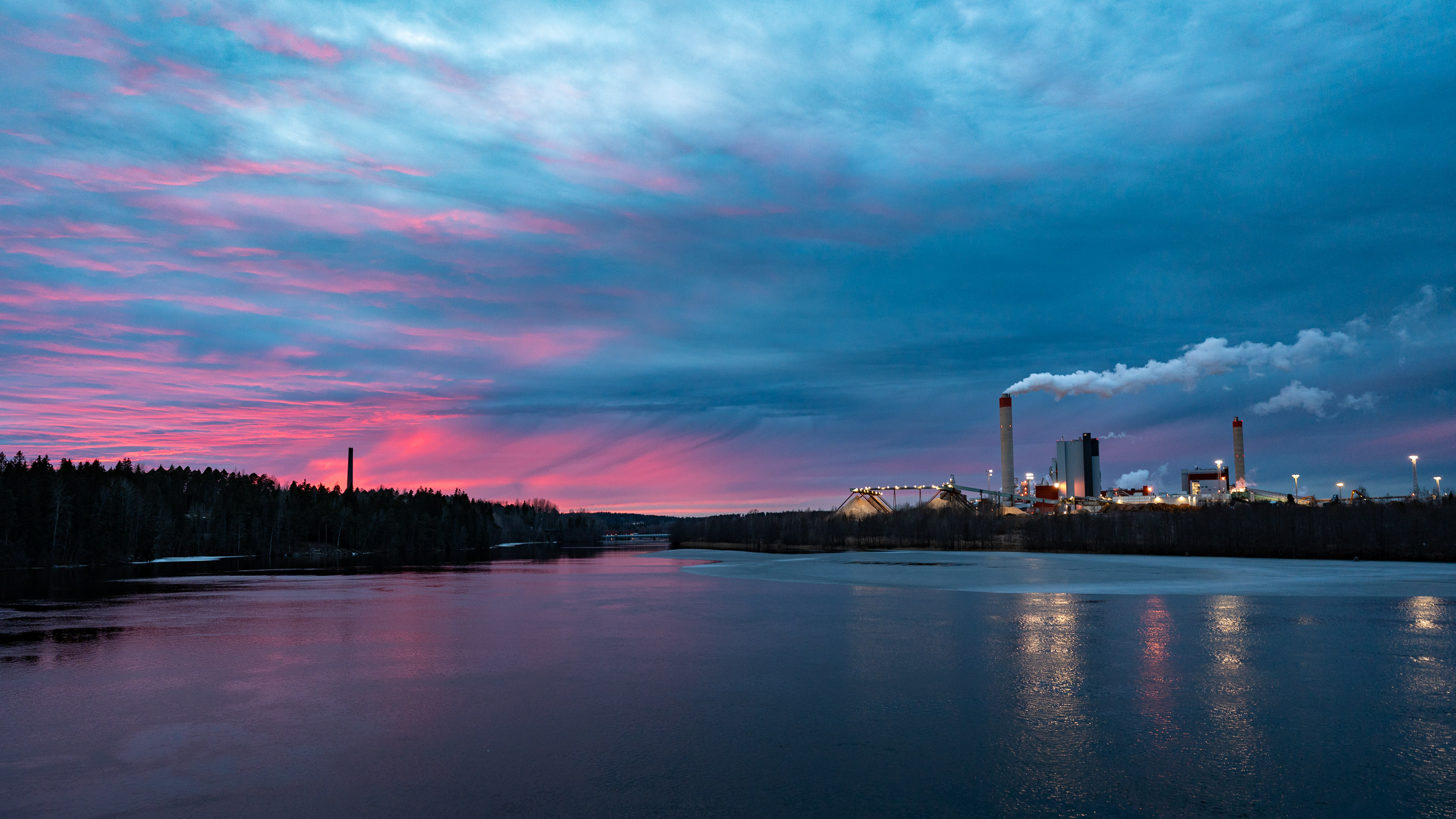 Maisema Kymijoelle Sääksniemen suunnasta. Oikealla UPM Kymi, vasemmalla taustalla Kymintehtaan vanhan höyryvoimalan piippu. (3.2026)