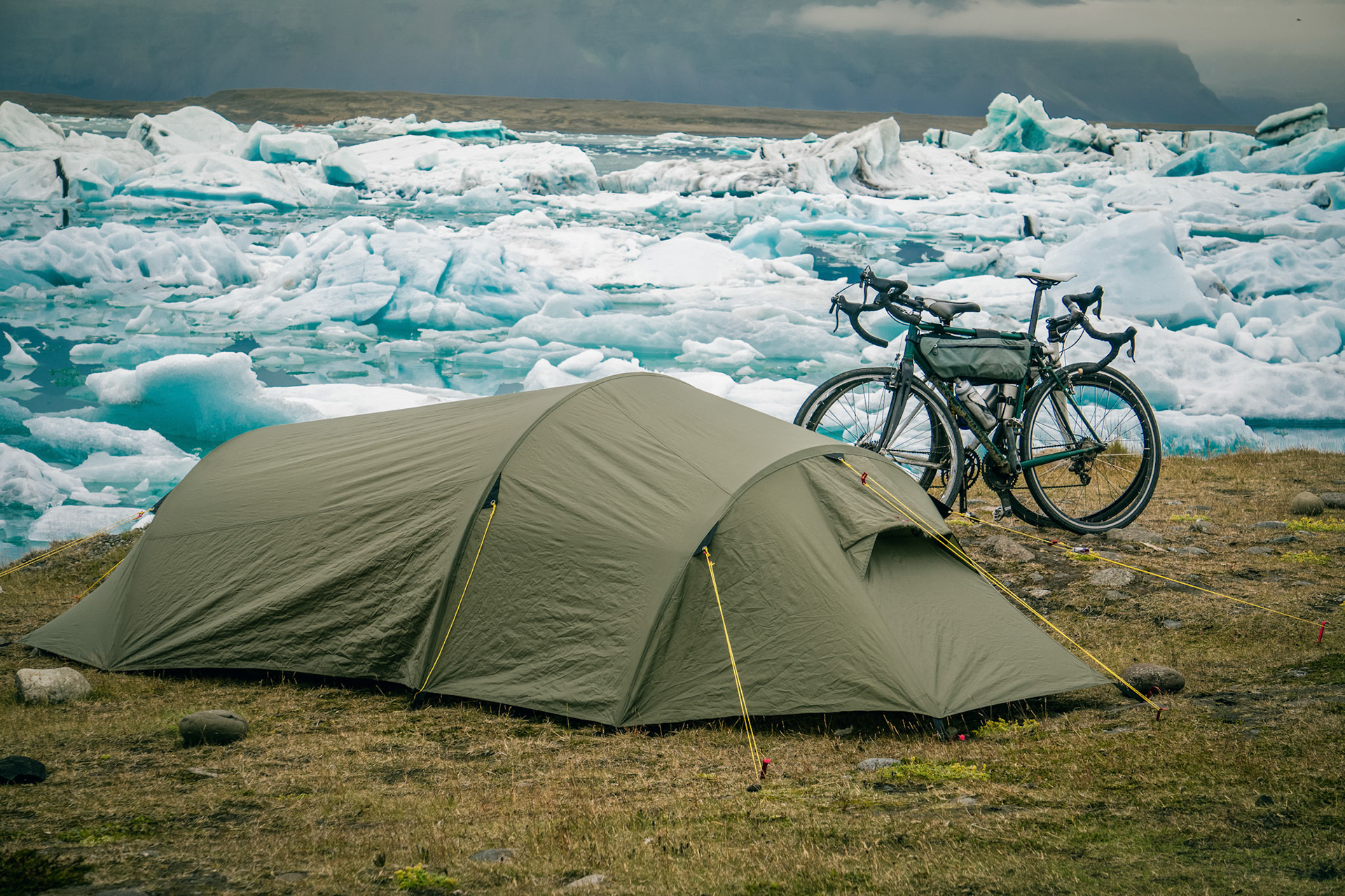 A tent and bicycles with icebergs in the background. Jokulsarlon, Iceland
